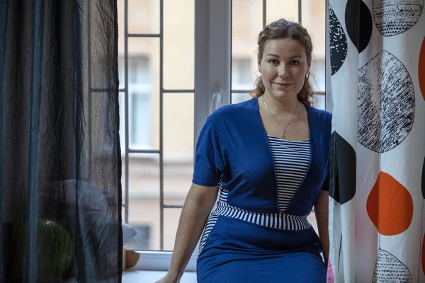 Vrouw Blauwe Jurk Zittend Vensterbank Donkere Kamer Kijkend Naar Camera — Stockfoto