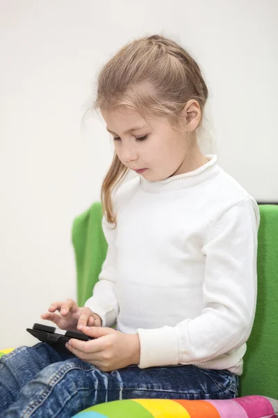 Une Jeune Fille Joue Téléphone Cellulaire Assise Intérieur — Photo