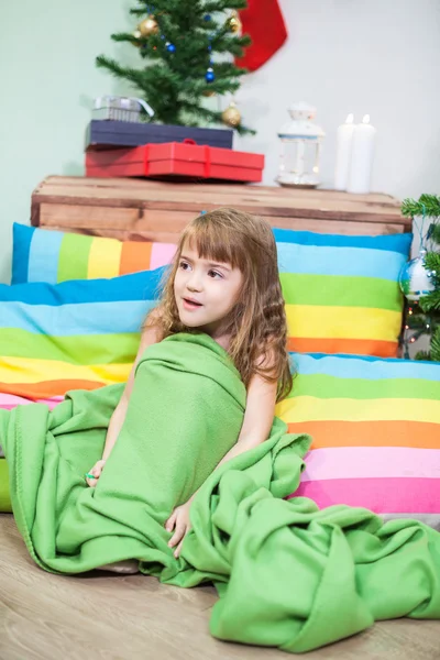 圣诞前夜 小女孩裹着毛毯 坐在五彩缤纷的枕头中间的地板上 — 图库照片