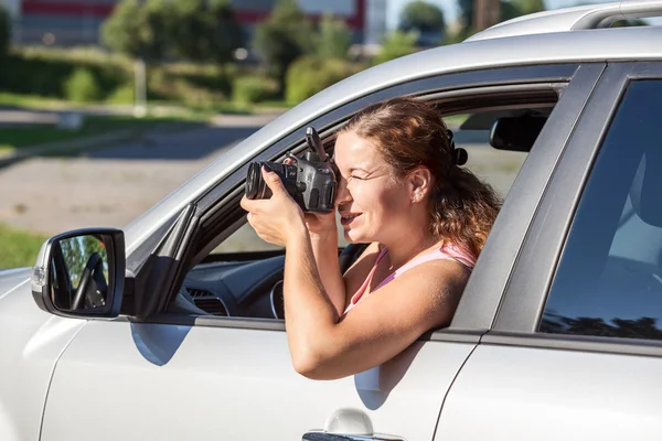 車の窓の外にもたれながら写真を撮る白人の若い女性 — ストック写真