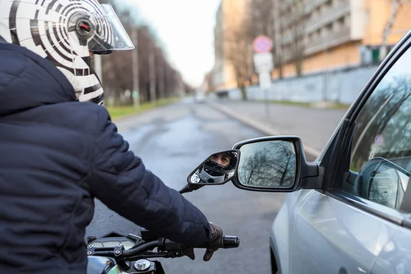 モーターサイクリストは 道路上の車と並んで立って 横のリアミラーは 移動中に触れて 互いに近いです — ストック写真