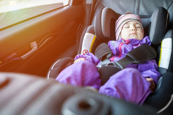 一岁的女孩睡在儿童安全座椅上 身体朝前水平 头枕可调 窗户上有阳光 — 图库照片