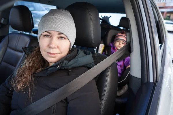 後ろの子供の安全シートに座っている彼女の息子と車を運転する母 安全ベルト — ストック写真