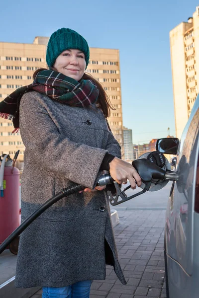 在城市自助加油站 快乐的中年妇女开车拿着油泵 — 图库照片