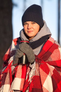 Kış mevsiminde genç ve güzel bir bayanı ısıtmak, eşarpla sarmak, güneş ışığıyla portre yapmak.