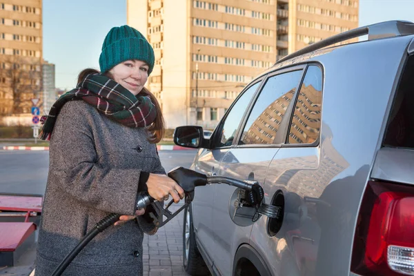 自用加油站有吸引力的妇女在其汽车中插入燃油泵喷嘴以填充柴油 — 图库照片
