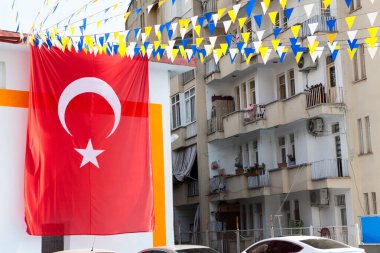 Caddedeki bir evin cephesinde asılı büyük Türk bayrağı