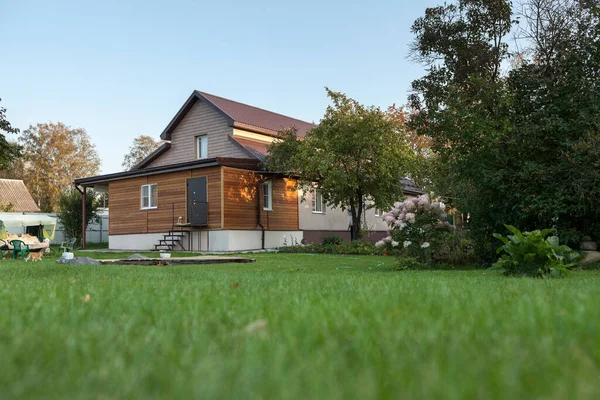 Low country house with back yard, green lawn, nobody