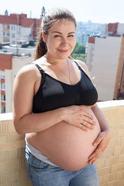 Mulher Grávida Bonita Varanda Vestindo Jeans Roupa Interior Segurando Sua — Fotografia de Stock