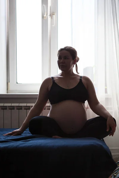怀孕的白人成年女性在卧室里静静地坐着 — 图库照片