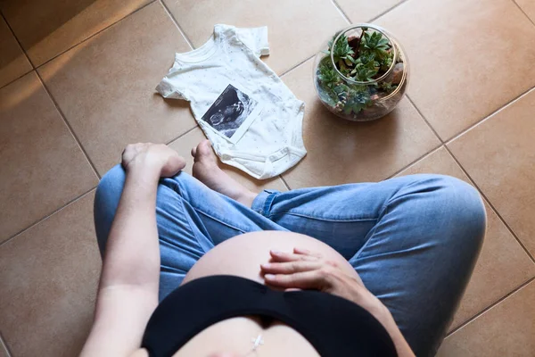 从上图看 怀孕的白人妇女享受着未来的母性生活 她的孩子穿着超音波照片和小西服 — 图库照片