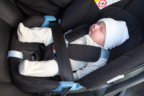 Nyfødt Hvit Baby Som Sover Inne Svart Bilsikkerhetssete – stockfoto