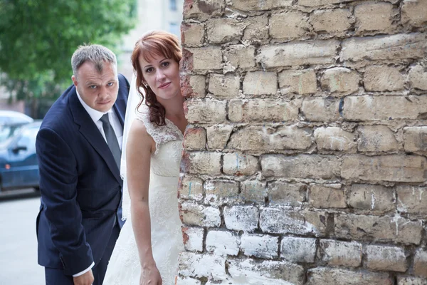 Newlywed couple peek around — Stock Photo, Image