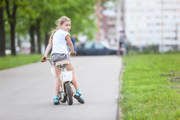 Menina montando uma bicicleta — Fotografia de Stock