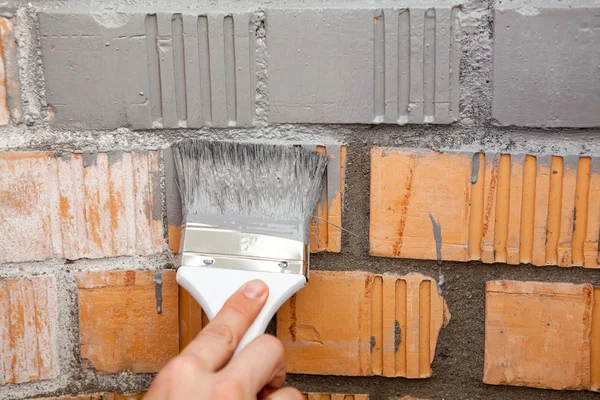 Paint brush on brick wall — Stock Photo, Image