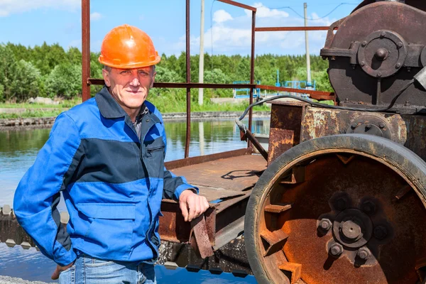 Dźwiękowiec pracownik w pobliżu mechanizm obróbki ścieków — Zdjęcie stockowe