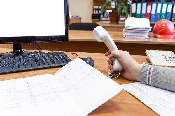 Engenheiro no trabalho com o telefone na mão — Fotografia de Stock