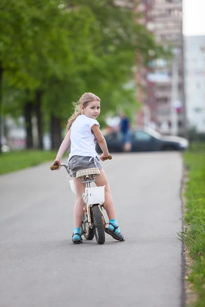 Meisje paardrijden een fiets in park — Stockfoto