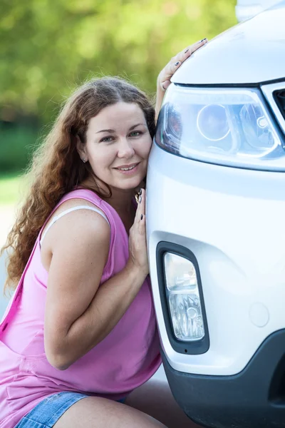 Женщина, наклоняющая ее щеку к автомобилю — стоковое фото