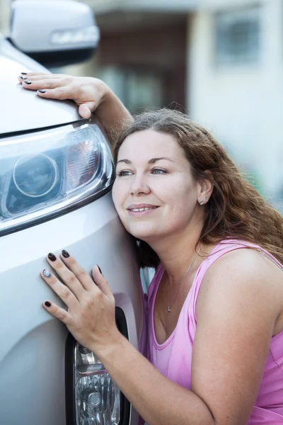 Jovem mulher atraente adorando seu novo carro — Fotografia de Stock