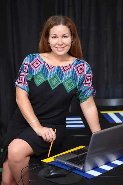 Pretty business woman sitting on desk — Stock Photo, Image