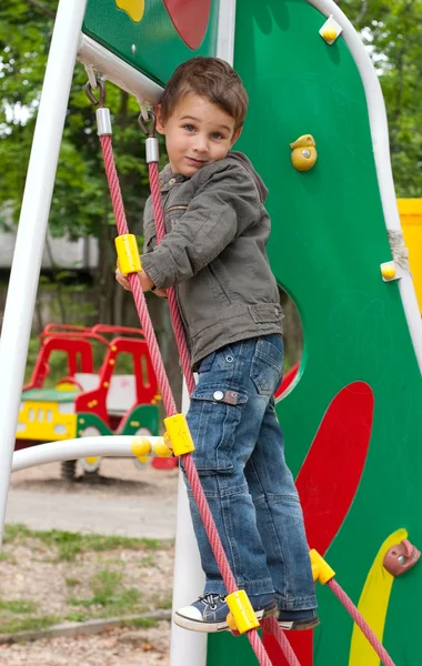 Kleine jongen die op de speelplaats speelt — Stockfoto