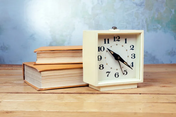 Old alarm clock with books — Stock Photo, Image