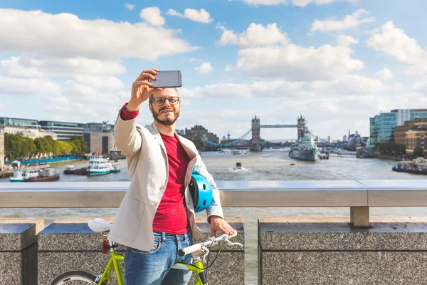 Hipstermannen tar en selfie i London mens han pendler – stockfoto