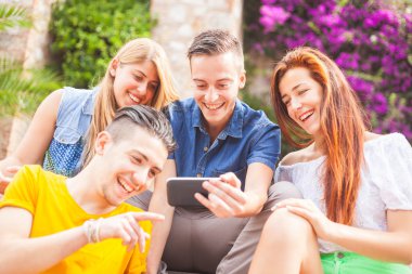 Gülüyor ve bir akıllı telefon arayan genç grup