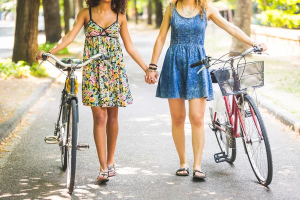 Two girls walking on the street holding hands — Stock Photo, Image