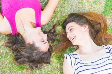 Çim üzerinde yalan ve gülüyor iki kız