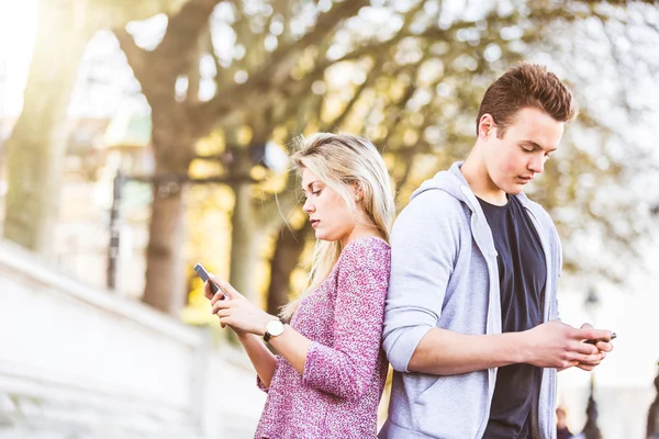Par ignorerar varandra och tittar på smart telefon — Stockfoto