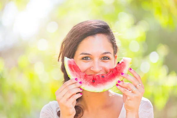 Krásná mladá žena v parku jíst meloun — Stock fotografie