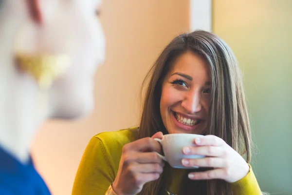 Two women in a cafe smiling and looking each other — Stock Photo, Image