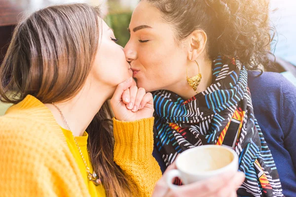 Lesbický pár líbání v kavárně — Stock fotografie
