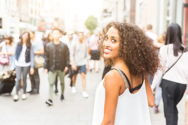 Mujer joven mirando a la cámara mientras camina en Londres — Foto de Stock