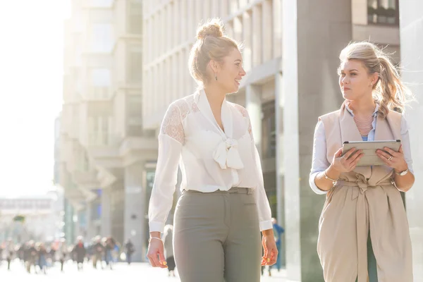 Två kvinnor promenader i staden och talar — Stockfoto