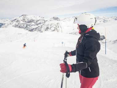 Dağ yamaçlarında kayak yapan mutlu bir kadın - güzel bir genç kadın kar tatilinde eğleniyor ve güzel güneşli bir kış gününde Livigno 'da - spor ve seyahat kavramları