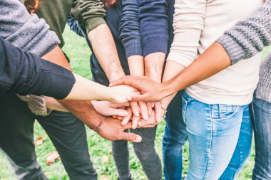 Çok ırklı insanların el ele tutuşması - karma ırklı bir grup arkadaş takım çalışmasına hazırlanıyor - dostluk ve yaşam tarzı kavramları