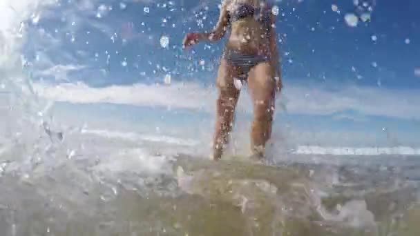 Szoros női futó tengerparti spalshing víz - Női láb kilátás fut a vízbe, akciókamera nézet - szabadidős és nyári vakáció fogalmak — Stock videók