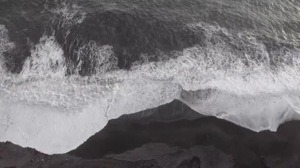 Вид сверху на величественные волны на черном песчаном пляже Вик - Удивительная воздушная сцена природы в Исландии - Природа и путешествия судьбы, идеально подходящие для фона — стоковое видео
