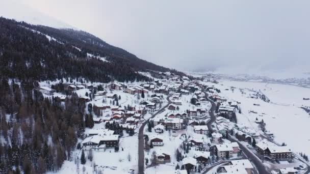 Dağ kasabasının ve kışın karla kaplı vadisinin havadan görünüşü - İtalya 'da evler ve yollar dağlar arasında güzel bir ortam - seyahat ve doğa kavramları — Stok video