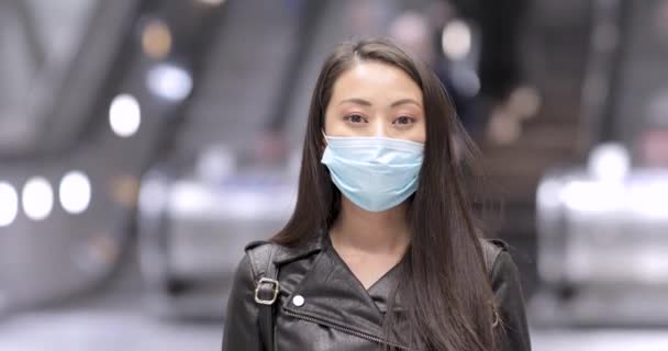 Chinese vrouw in Londen draagt gezichtsmasker ter bescherming tegen covid 19 coronavirus - jonge Aziatische vrouw portret in een drukke openbare plaats te beschermen tegen virus - gezondheid en levensstijl — Stockvideo