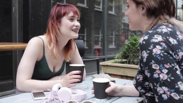Londra 'da birlikte kahve içen en en iyi arkadaşlar - kafede konuşan, gülen ve eğlenen iki genç kadın - gerçek insan modelleriyle yaşam tarzı ve arkadaşlık kavramları — Stok video