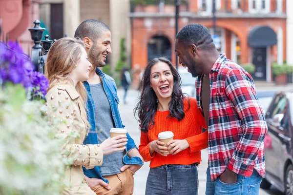 Londra 'da çok ırklı bir grup arkadaş birlikte eğleniyor - iki kız ve iki erkek, çeşitli ve kapsayıcı grup, konuşuyorlar ve gülüyorlar - yaşam tarzı ve arkadaşlık kavramları