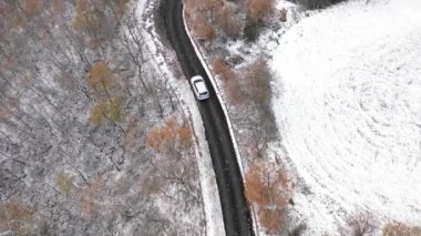 Karlı kırsal yolda araba sürüşünün havadan görünüşü