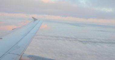 Gün batımında bulutların üzerinde uçan uçak