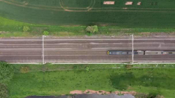 田園地帯の鉄道と列車の通過、空中風景 — ストック動画