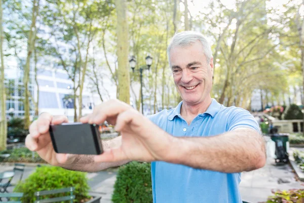 Ανώτερος άνθρωπος, λαμβάνοντας μια selfie στο πάρκο — Φωτογραφία Αρχείου