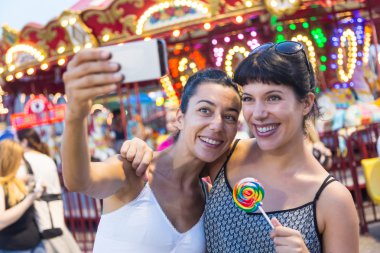 Happy Young Women Taking Selfie at Luna Park clipart